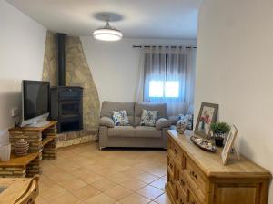 a living room with a couch and a tv at Chalet La Garrocha in Chiclana de la Frontera