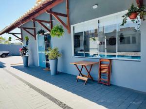 una mesa y una silla en el lateral de un edificio en CHALÉS GUARAÍPE, en Guarapari