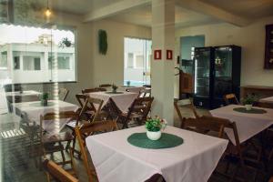 um restaurante com mesas e cadeiras com flores em CHALÉS GUARAÍPE em Guarapari