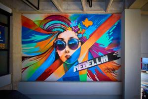 una gran pintura de una mujer con gafas de sol en una pared en MANGATA LIVING, en Medellín