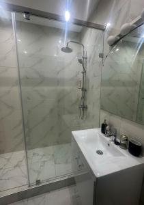 Appartement agréable en plein coeur de Marrakech pour 2 à 4 Personnes في مراكش: حمام أبيض مع دش ومغسلة