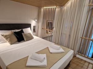 ein Schlafzimmer mit einem großen Bett mit zwei Handtüchern darauf in der Unterkunft Loft Studios in Artemida