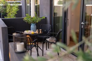 a patio with chairs and a table with a vase at Loft Studios in Artemida