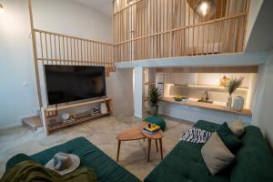 ein Wohnzimmer mit einem grünen Sofa und einem TV in der Unterkunft Loft Studios in Artemida