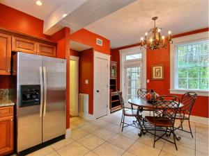 una cucina con pareti arancioni e tavolo con sedie di Forsyth Park West Garden Level a Savannah