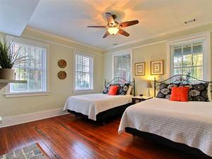 una camera con 2 letti e un ventilatore a soffitto di Forsyth Park West Garden Level a Savannah