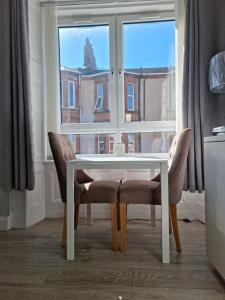 a table and two chairs in front of a window at Largs Apartment, Spacious & Modern 1 Bed near beach & shops in Largs