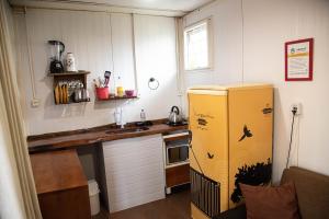 a kitchen with a yellow refrigerator and a counter at Chalé Container Nobres Asa Própria in Estivado