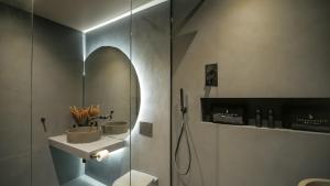 a bathroom with a shower and a sink and a mirror at Midnight by The Heim Residences in Manchester