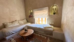 - une petite chambre avec un lit et une table dans l'établissement Alliance Berbère - Vallée d'Aït Bouguemez, à Timit