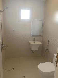 a white bathroom with a sink and a toilet at Mayyon Airport 101 in Riyadh