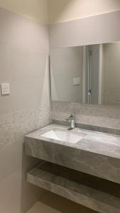 ein Bad mit einem Waschbecken und einem Spiegel in der Unterkunft Mayyon Airport 101 in Riad