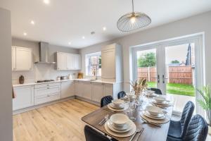 a kitchen and dining room with a table and chairs at Green Park House, Private Garage and Parking in Coventry