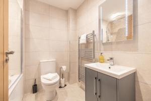 a white bathroom with a toilet and a sink at Green Park House, Private Garage and Parking in Coventry