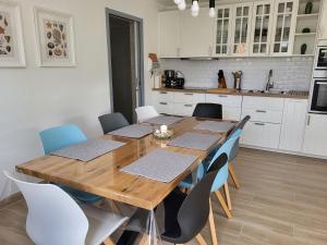 a dining room with a wooden table and chairs at Le clos de la cote d'Emeraude in Saint-Benoît-des-Ondes