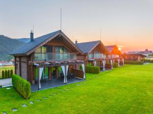 a row of wooden houses on a grass field at Samovilla in Govedartsi