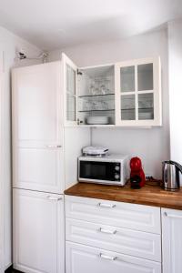 a kitchen with white cabinets and a microwave at Lugano Boat Apartment in Lugano