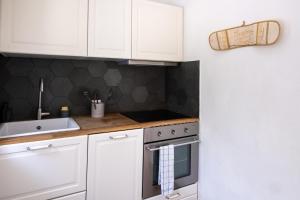 a kitchen with white cabinets and a stove top oven at Lugano Boat Apartment in Lugano