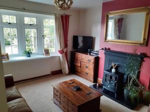 a living room with a fireplace and a tv at 3 bedroom village house 