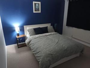 a bedroom with a bed and a blue wall at 3 bedroom village house in Cosby