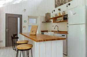 uma cozinha com um frigorífico branco e um balcão com bancos em BOG Nórdica 2 em Villa La Angostura
