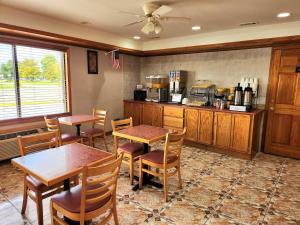 a kitchen with two tables and chairs and a counter at Days Inn by Wyndham Slidell in Slidell