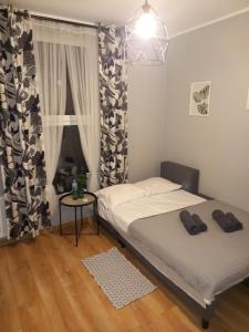 um pequeno quarto com 2 camas e uma janela em Przystanek Opole - MIKROAPARTAMENTY em Opole