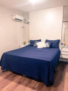 a bedroom with a blue bed with blue pillows at Apto próximo ao Shopping Boulevard in Belém