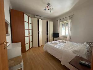 帕索斯庫洛的住宿－Casa di Roberta，卧室配有白色的床和窗户。