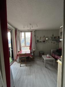 Chaleureux Logement - 4 Couchages في Uvernet: غرفة معيشة مع طاولة ونافذة