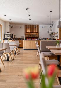a restaurant with tables and chairs and a kitchen at Aparthotel Ursprung in Schladming