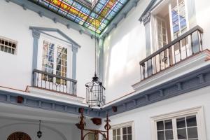 a room with two windows and a stained glass ceiling at PALACIO DON CARLOS in Jerez de la Frontera