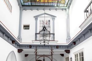 Elle offre une vue sur le plafond d'un bâtiment doté d'un lustre. dans l'établissement PALACIO DON CARLOS, à Jerez de la Frontera