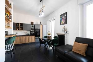 a living room with a couch and a table and a kitchen at Apartment Design 5 Stelle in Novara