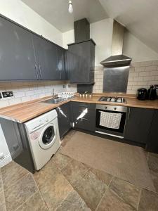 a kitchen with a stove and a washing machine at Willesden J Guest Home 4 in London