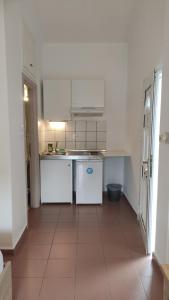 a kitchen with white appliances and a tile floor at BLEU- VERT in Prinos