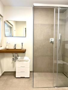 y baño con ducha acristalada y lavamanos. en Streiter Rooms en Bolzano