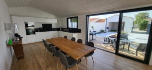 een keuken en eetkamer met een houten tafel en stoelen bij Jolie demeure à proximité de La Rochelle in La Jarrie