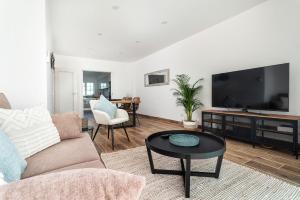 a living room with a couch and a flat screen tv at Privilege Casa dos Capuchinhos, in the heart of Faro in Faro