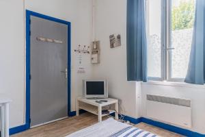 une chambre avec un ordinateur sur une table et une fenêtre dans l'établissement Bureau Lesparre-médoc, le Port, à Lesparre-Médoc