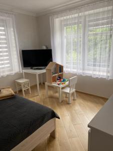 a bedroom with a bed and a table and a desk at Pokoje gościnne Orlovo DT in Gdynia