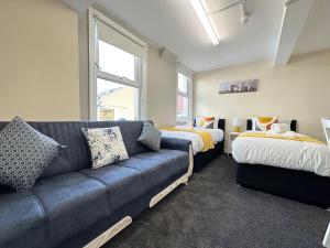 a living room with a couch and two beds at Comfy City Stay in Colchester