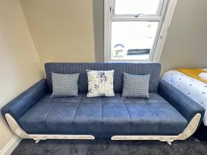 a blue couch in a room with a window at Comfy City Stay in Colchester