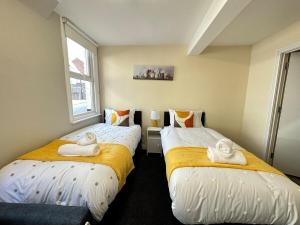 two beds in a small room with towels on them at Comfy City Stay in Colchester