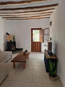 ein Wohnzimmer mit einem Tisch und einer Holztür in der Unterkunft Casa De La Familia - Appartement in Baza