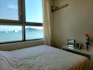 a bedroom with a bed and a large window at Hot place in Busan