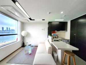 Hot place في بوسان: غرفة معيشة مع أريكة بيضاء وطاولة