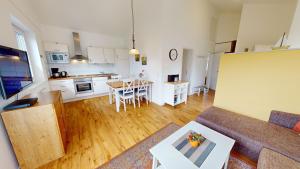 a living room and kitchen with a couch and a table at Feriendorf Südstrand Haus 35 in Pelzerhaken