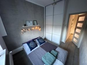 1 dormitorio con 1 cama con almohadas azules en Pastelowy Olsztyn, en Olsztyn