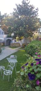 a table and chairs in a yard with flowers at BLEU- VERT in Prinos